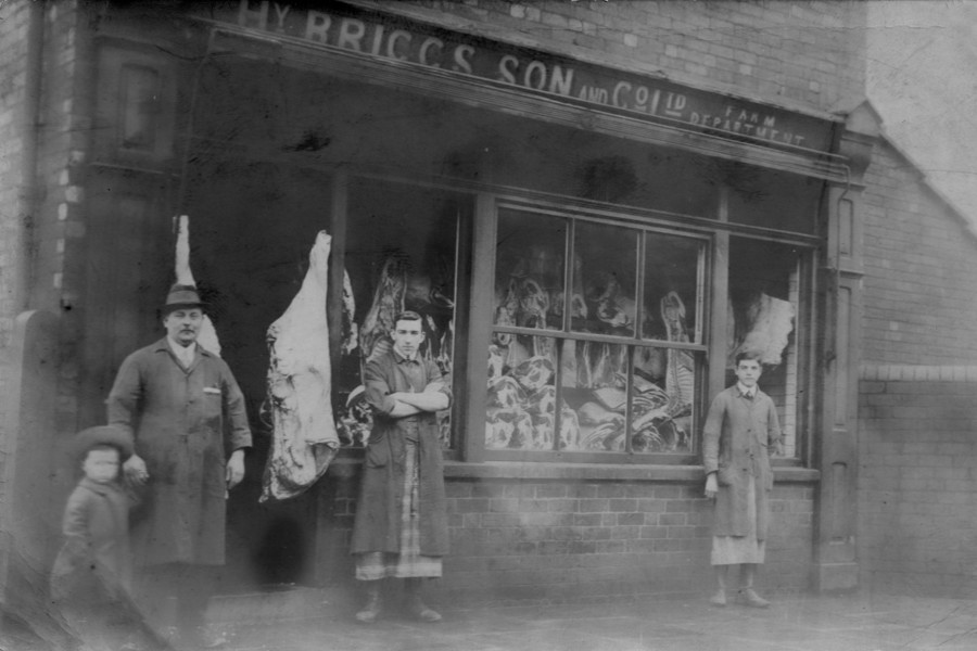 An old black and white photo of a butchers shop.