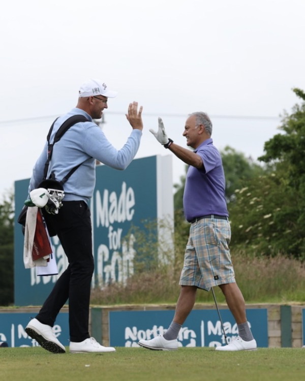 PGA Professional Mark McGeehan high fives another golfer.