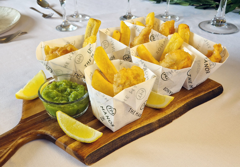 Mini portions of fish and chips on a serving board.