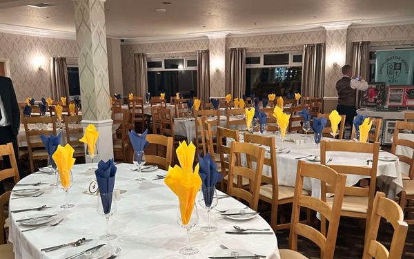 Dining tables in The View at The Manor set with yellow and blue napkins.