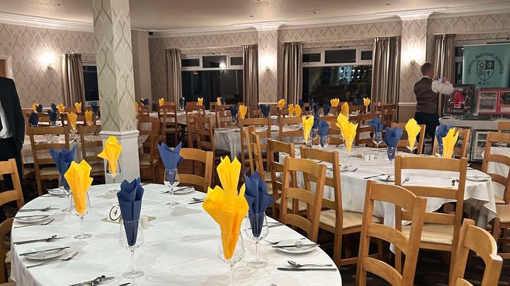 Dining tables in The View at The Manor set with yellow and blue napkins.