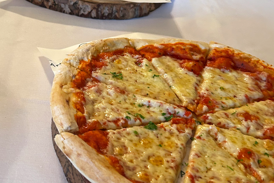 Margarita pizza presented on greaseproof paper printed with The Manor logo on a buffet table at The Manor Leeds.