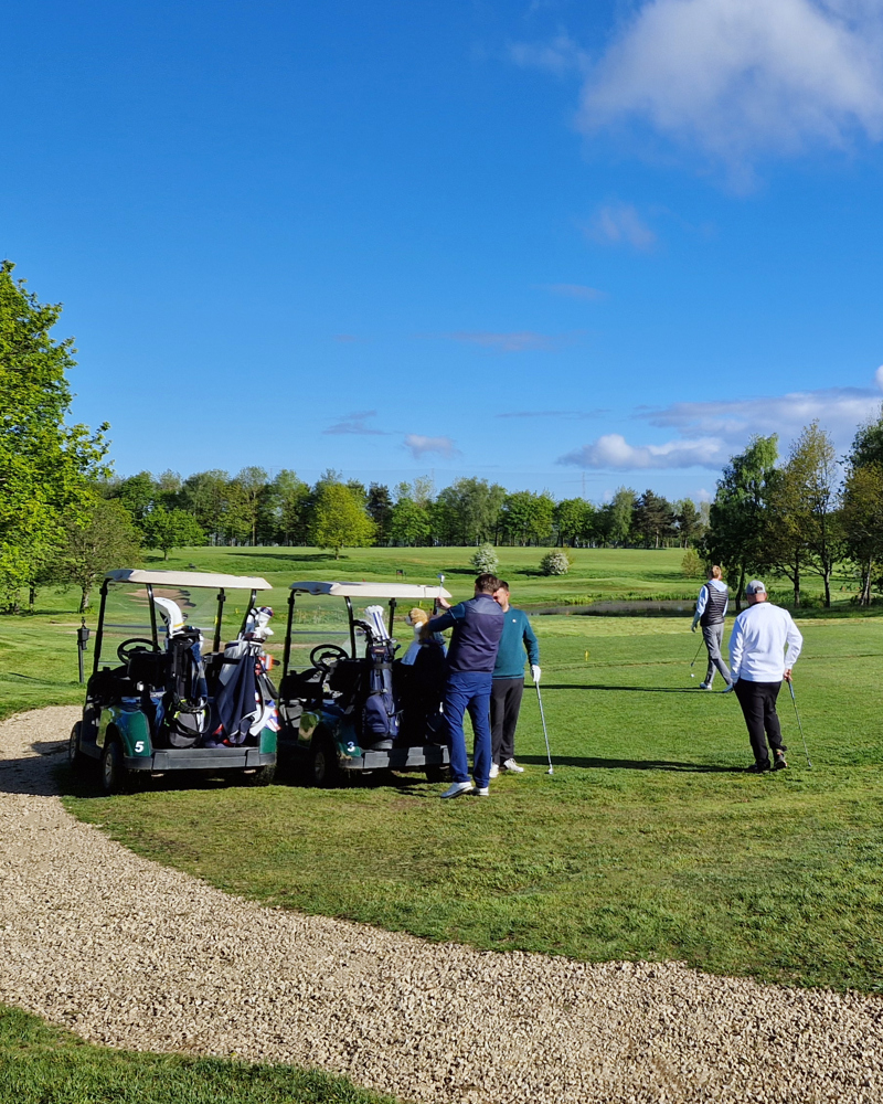 A group of 4 golfers with two buggies beside the 7th tee at The Manor Leeds.
