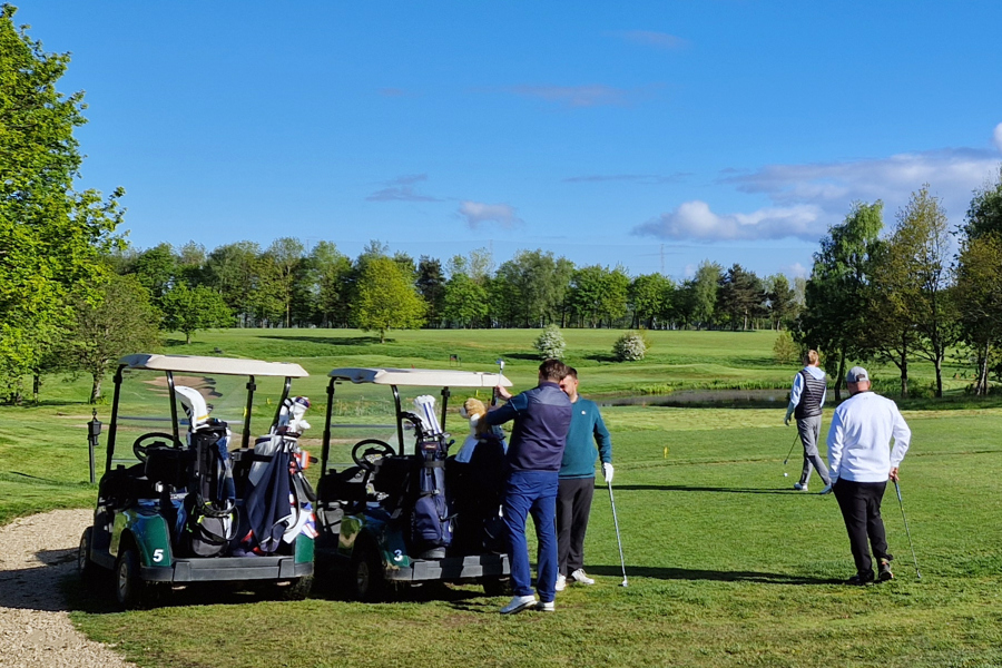 A group of 4 golfers with two buggies beside the 7th tee at The Manor Leeds.