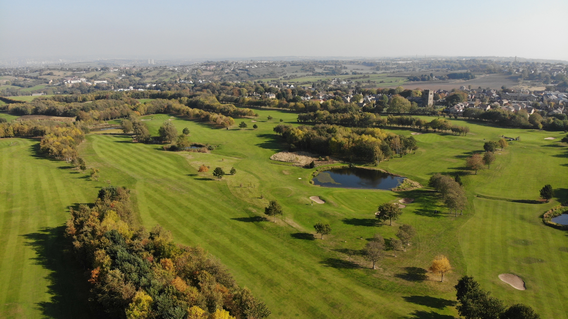 A south-facing aerial photograph looking over The Manor golf course in autumn.