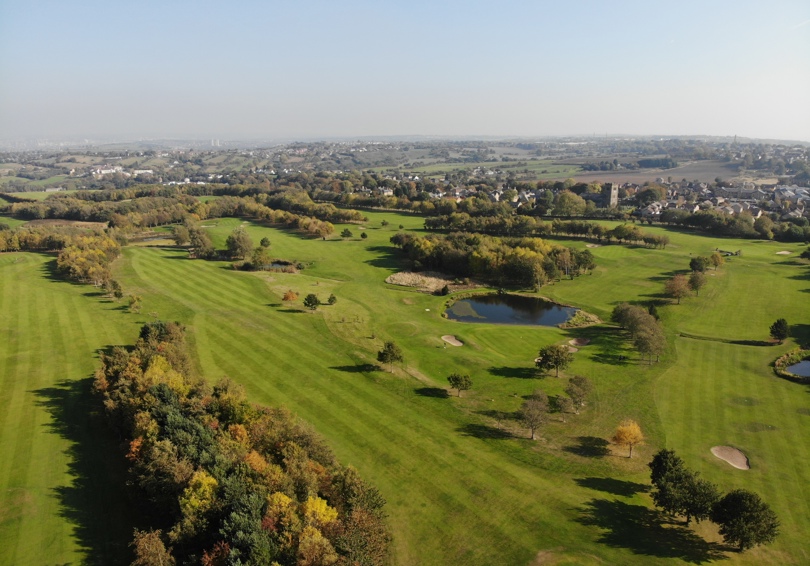 A south-facing aerial photograph looking over The Manor golf course in autumn.