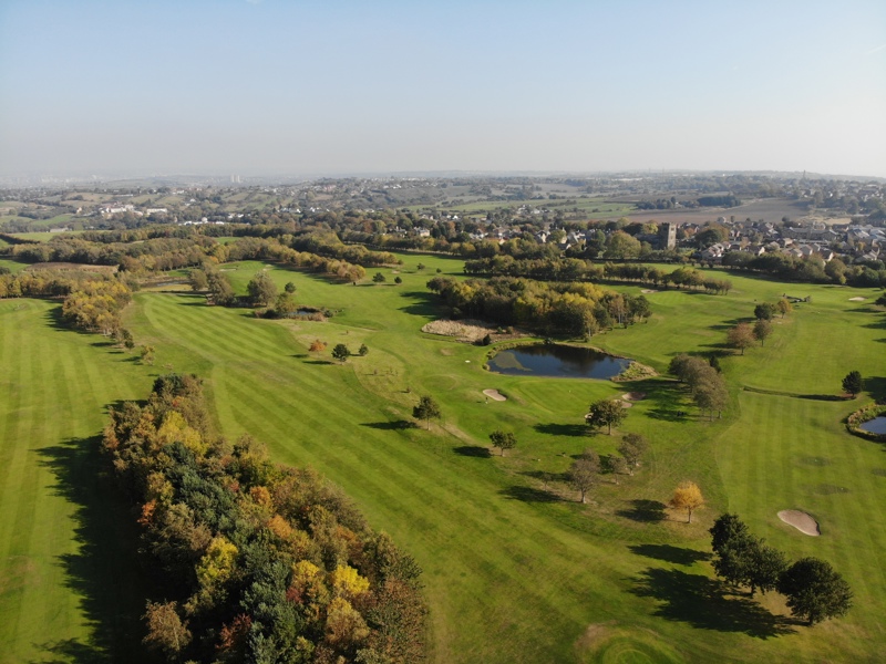 A south-facing aerial photograph looking over The Manor golf course in autumn.