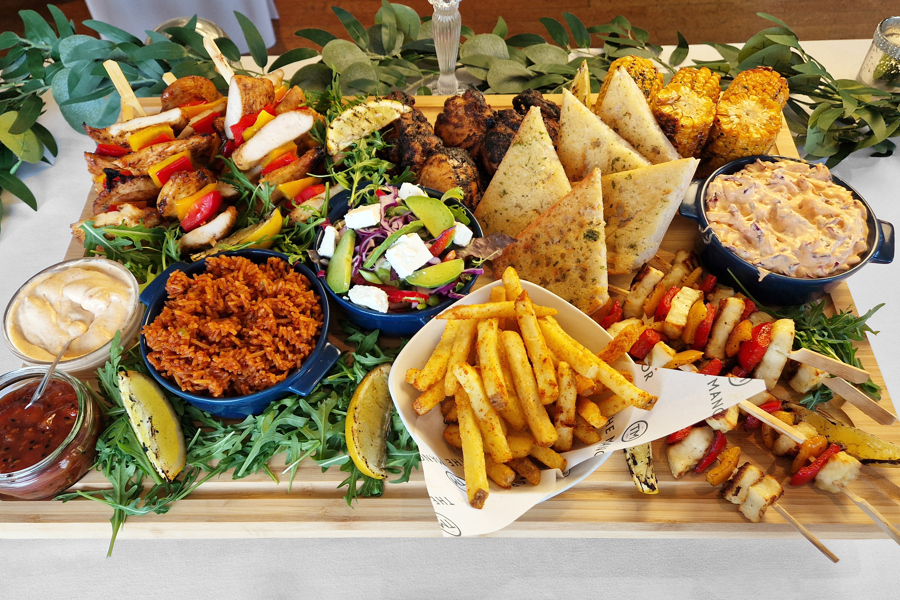 The Peri-Peri sharing board at The Manor Leeds; Peri-Peri Chicken Thighs, Grilled Chicken & Pepper Skewers, Grilled Halloumi & Pepper Skewers, Garlic Bread, Spicy Rice, Corn on the Cob, Skin-on Wedges, Peri-Peri Coleslaw and Rainbow Leaf Salad.