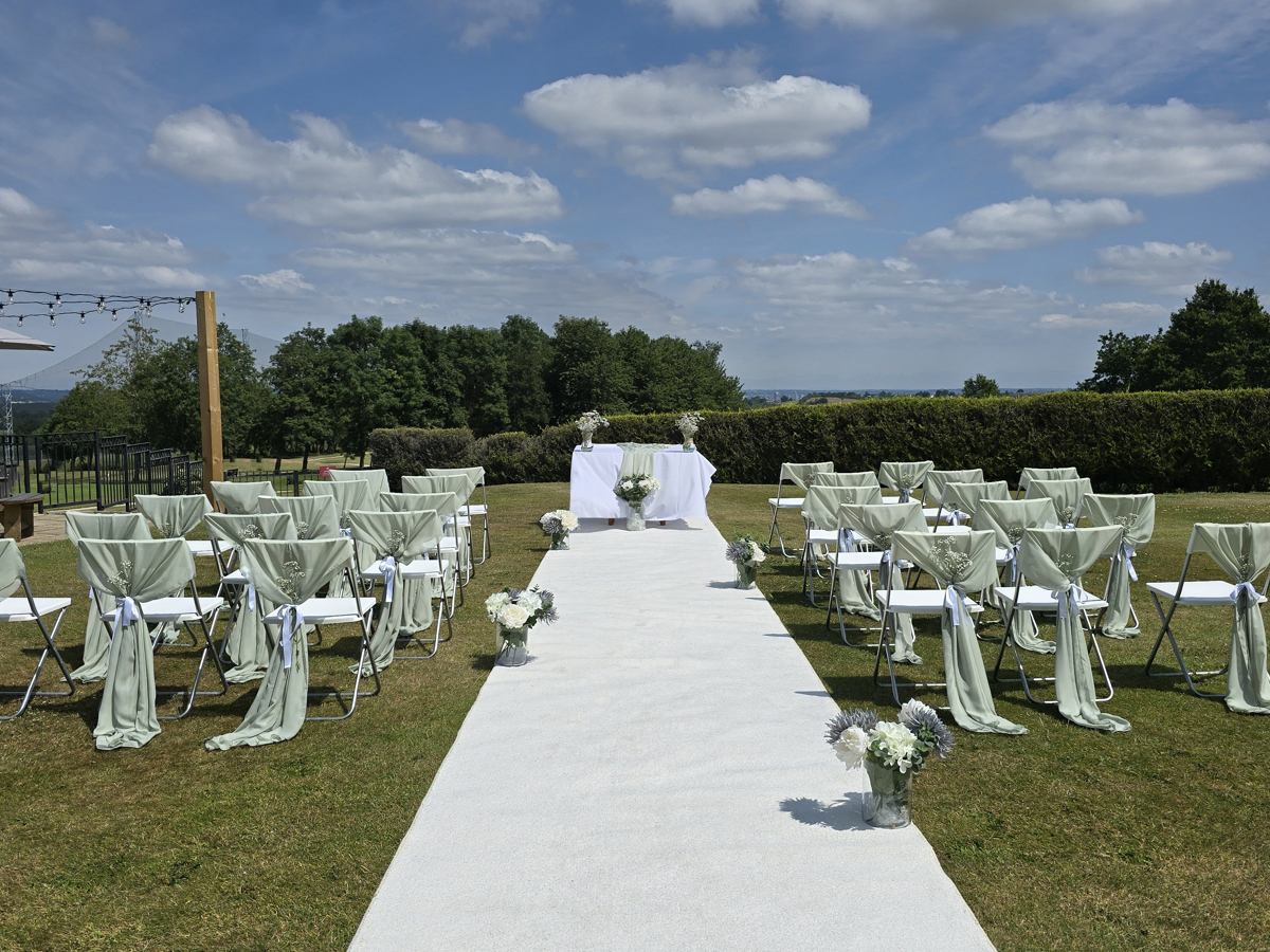 Aisle and chairs set for an outdoor wedding ceremony on The Lawn at The Manor.